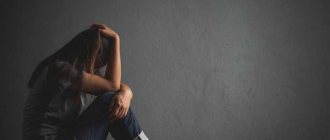 Girl holding her head while sitting on the floor