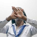 Девушка прячет руками лицо