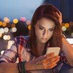 Девушка смотрит в телефон