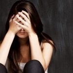 Girl covers her face with her hands