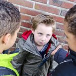 Two boys pinned a third boy to the wall