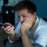 Грустный мужчина сидит с пультом в руках